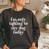 a woman sitting on a bed wearing a black sweatshirt that says i'm only