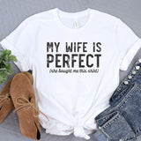 a white t - shirt that says, my wife is perfect she taught me this