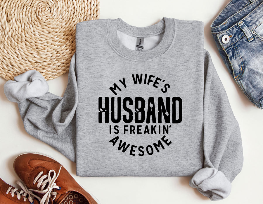 a sweatshirt that says, my wife's husband is freakin'awesome