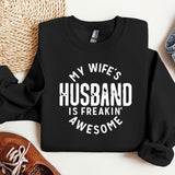 a black sweatshirt that says, my wife's husband is freakin'awesome