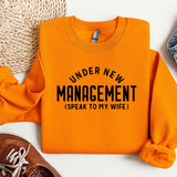 a sweater that says under new management speak to my wife