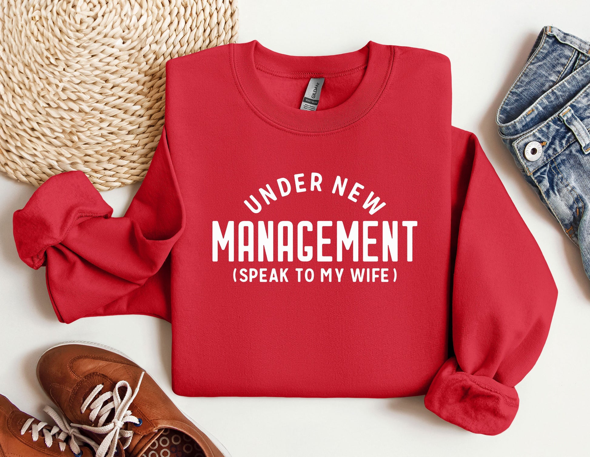 a red sweater that says under new management speak to my wife
