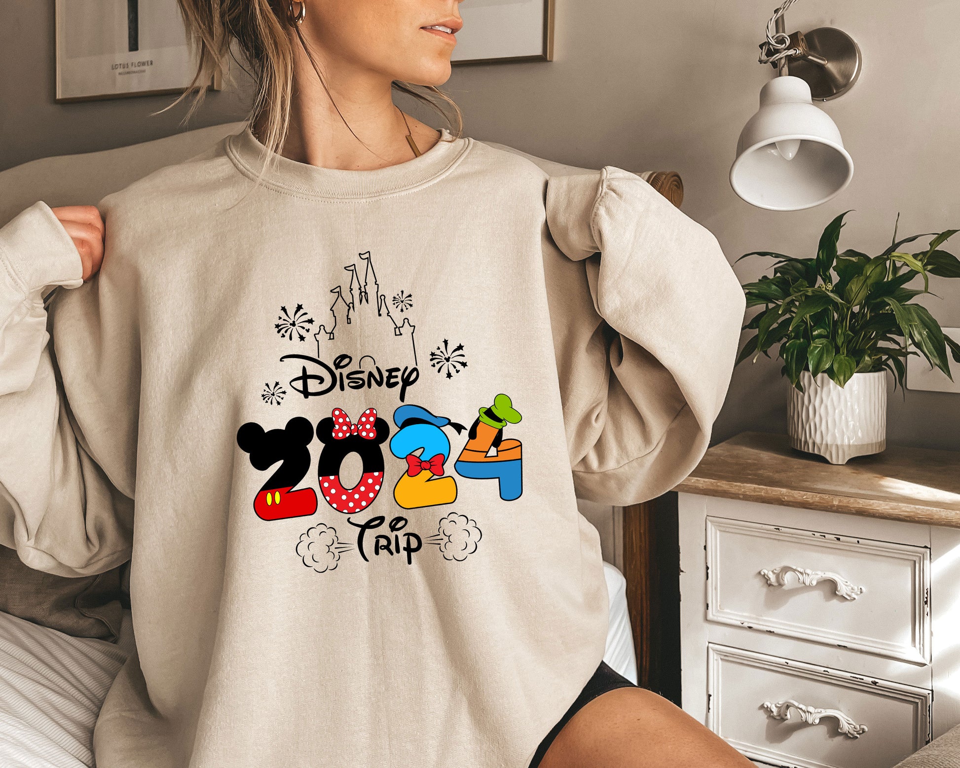 a woman wearing a sweatshirt with mickey mouse on it