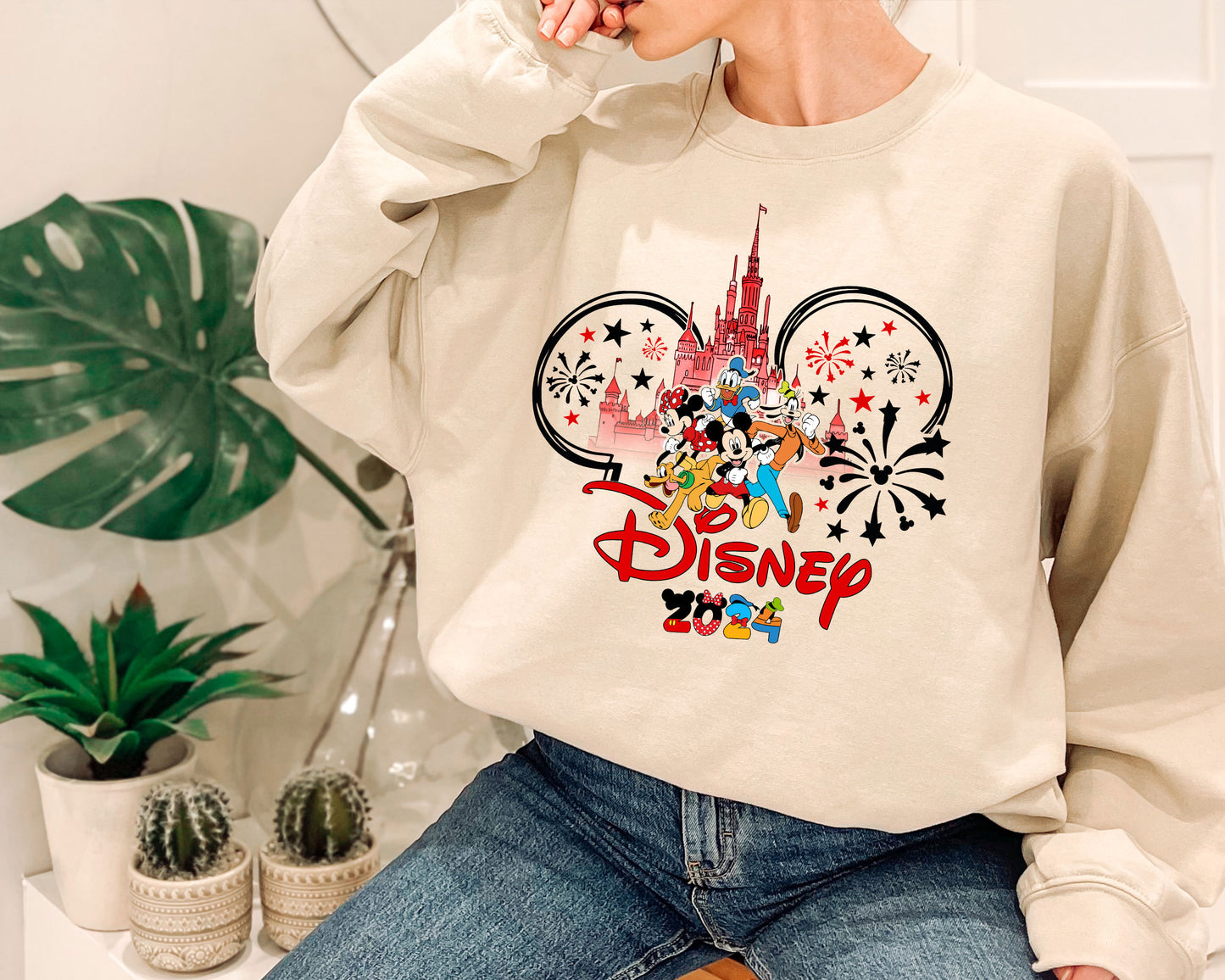 a woman sitting on a chair wearing a disney sweatshirt