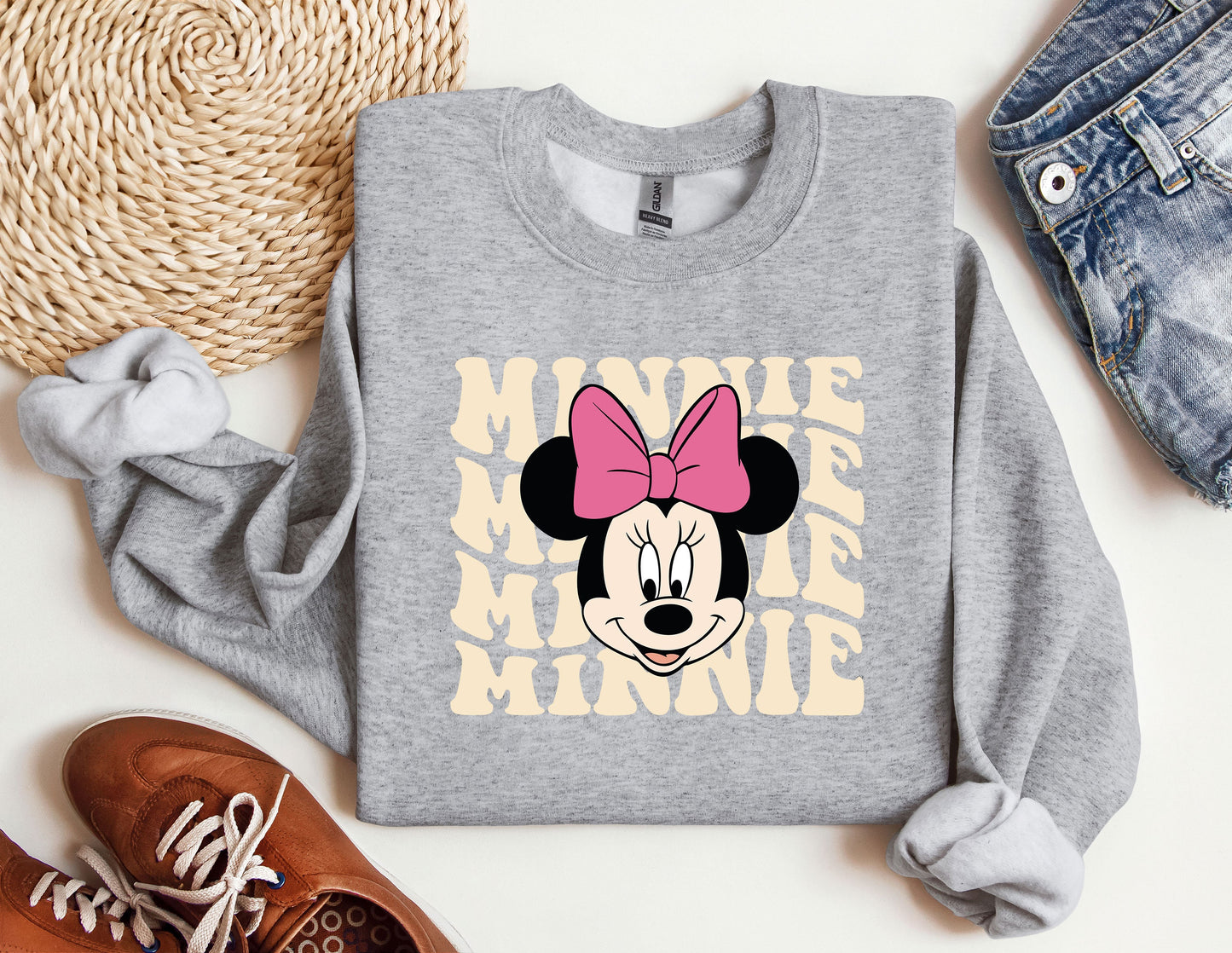 a mickey mouse sweatshirt with a pink bow on it