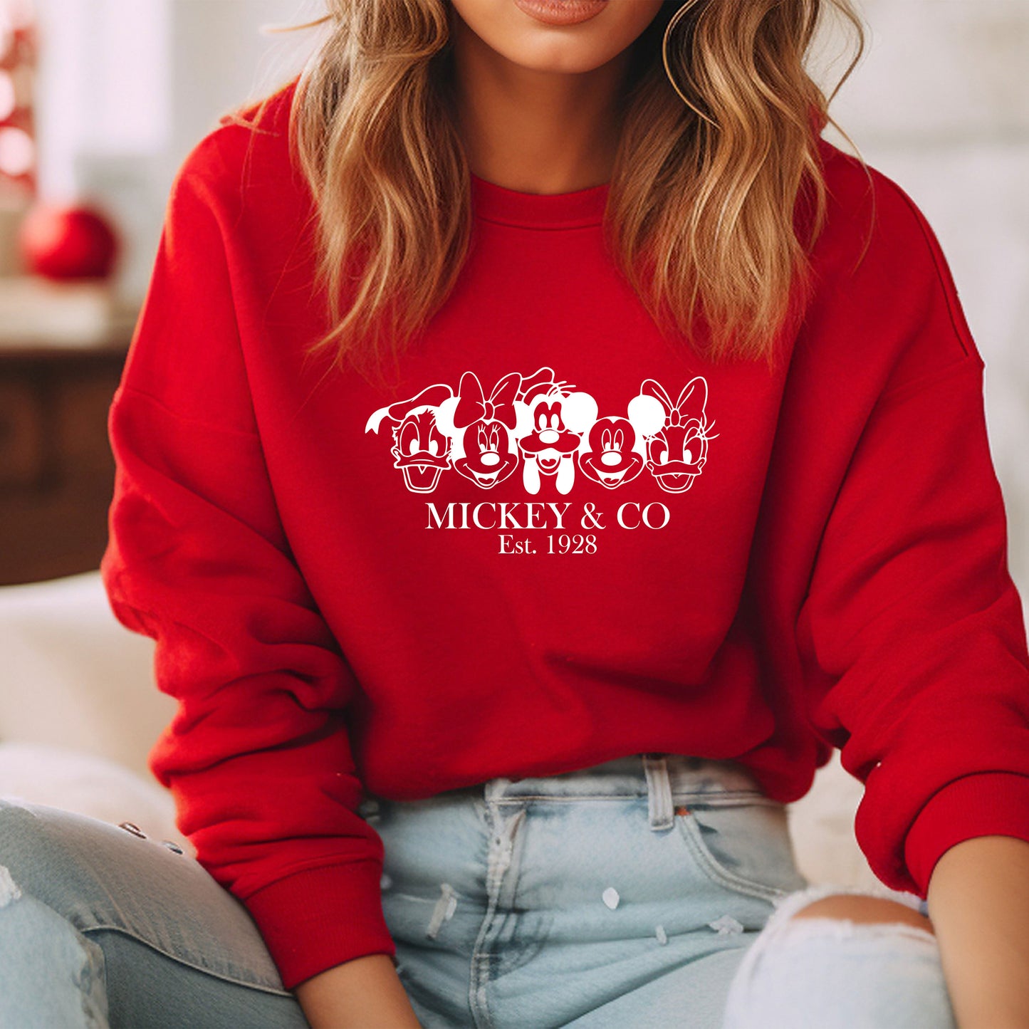 a woman wearing a red mickey mouse sweatshirt