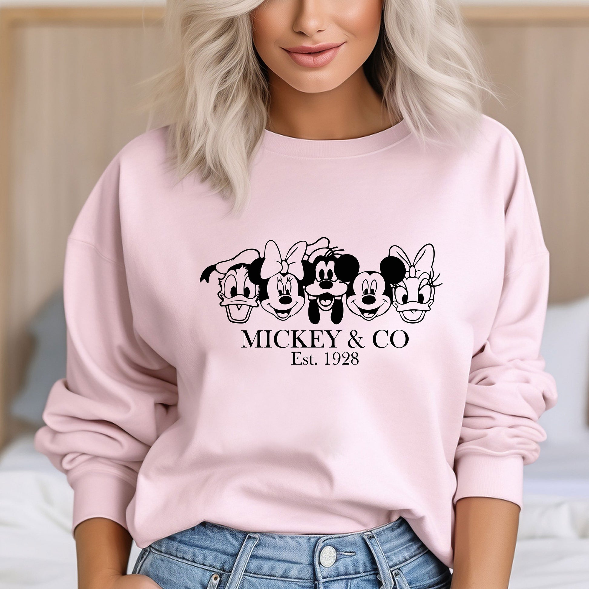 a woman wearing a pink mickey and mickey mouse sweatshirt