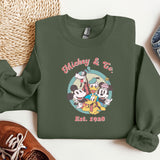 a green sweatshirt with mickey and friends on it