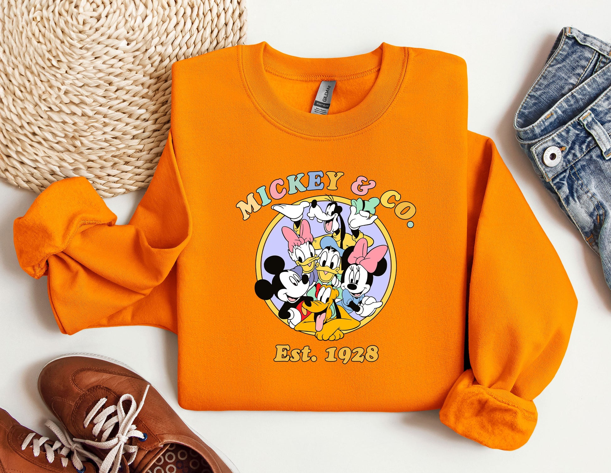 an orange mickey mouse shirt next to a pair of shoes