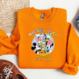 an orange mickey mouse shirt next to a pair of shoes