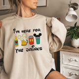 a woman wearing a sweatshirt that says i'm here for the drinks
