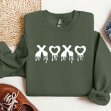 a green sweatshirt with white paint dripping down the side of it