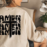 a woman sitting in a chair wearing a sweatshirt with a cross on it