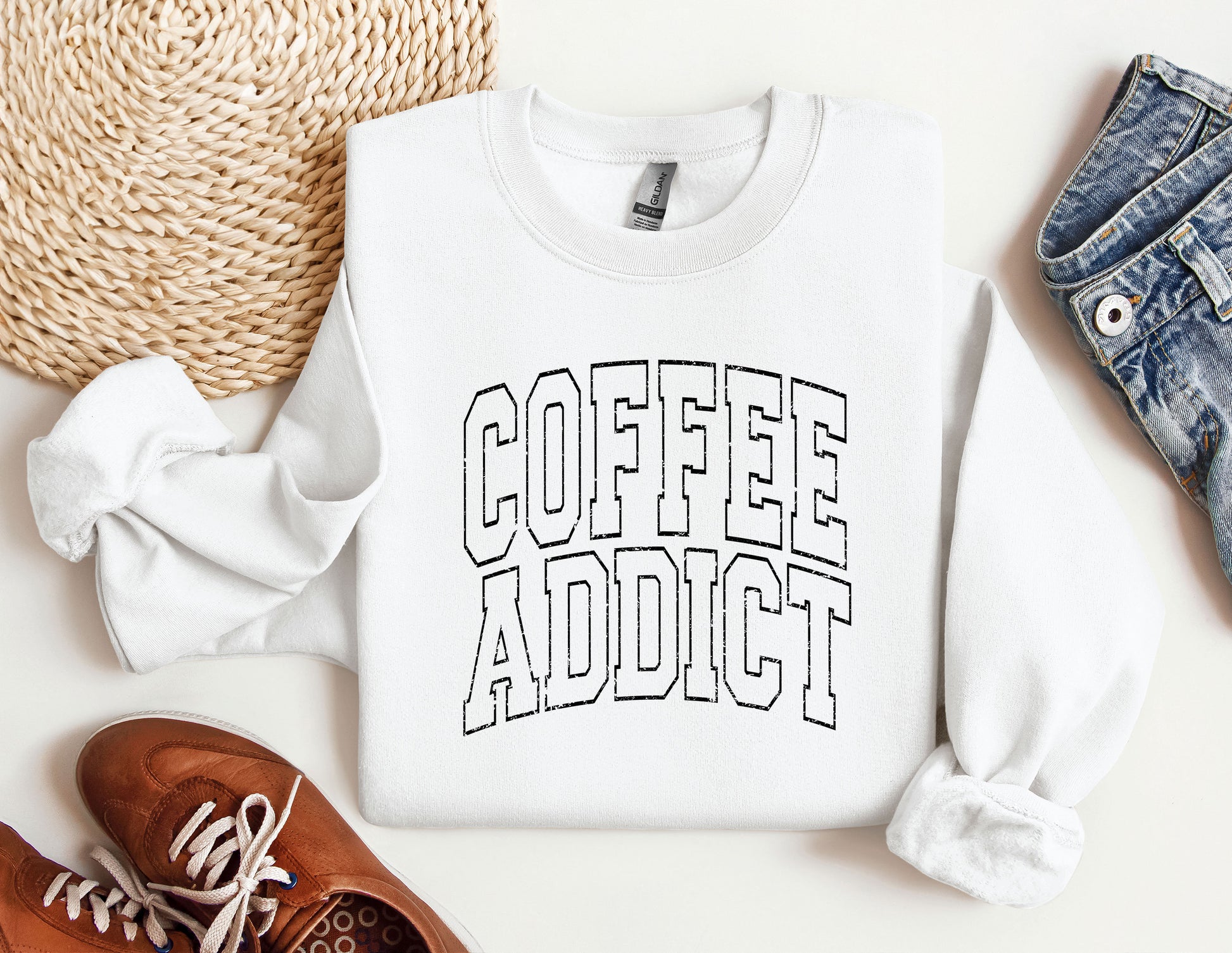 a sweater that says coffee addict next to a pair of shoes