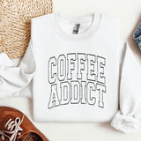 a sweater that says coffee addict next to a pair of shoes