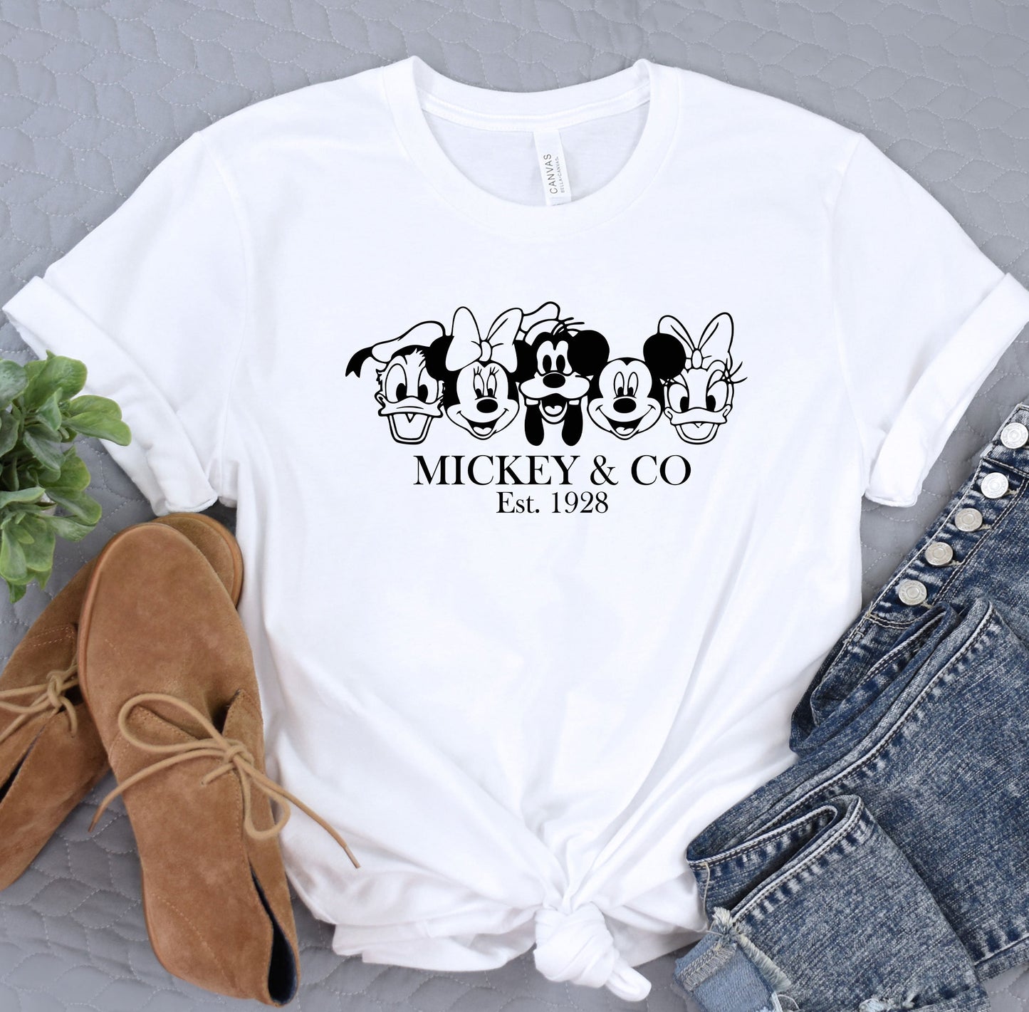 a mickey and mickey mouse t - shirt next to a pair of jeans