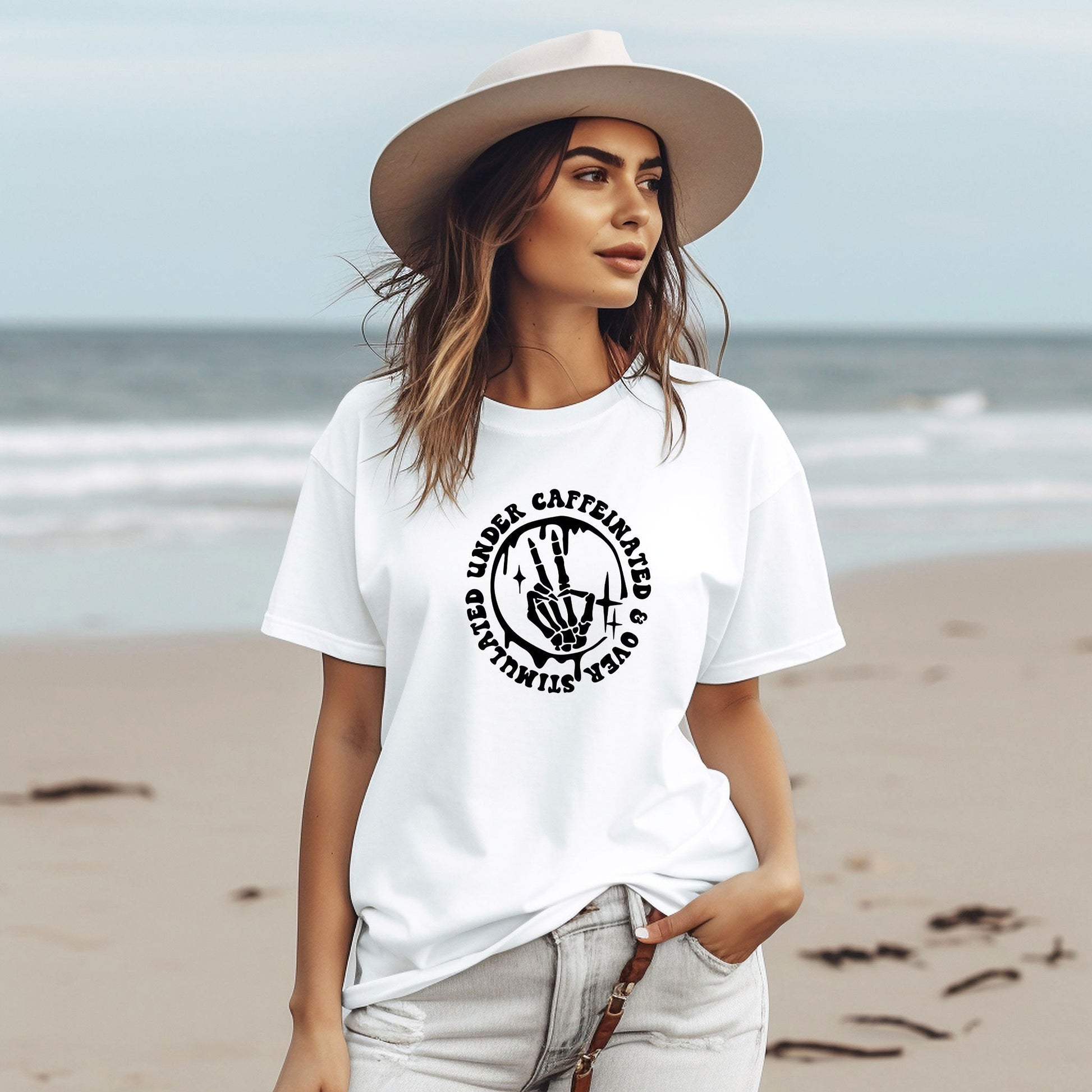 a woman standing on a beach wearing a hat