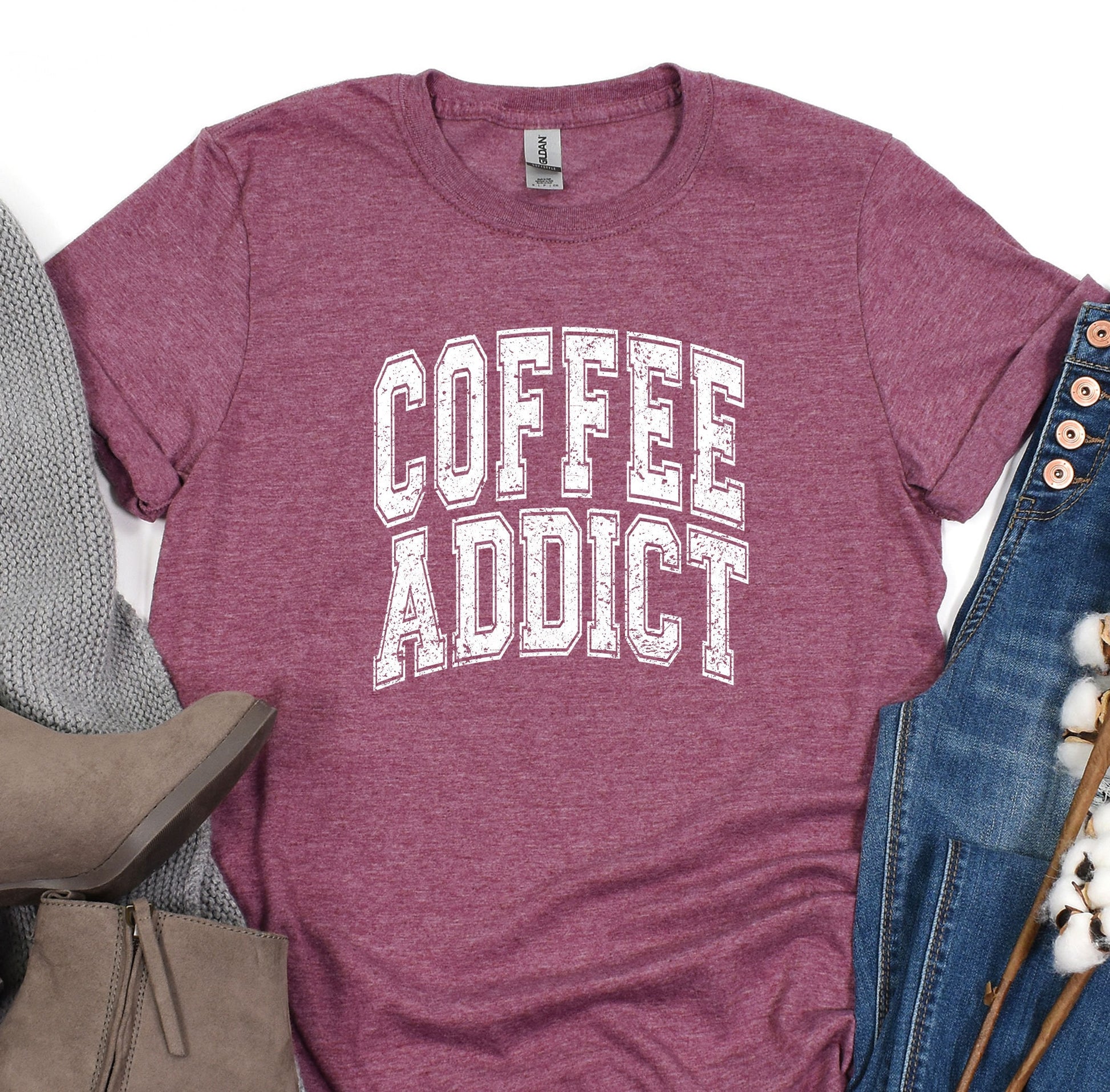 a t - shirt that says coffee addict next to a pair of jeans