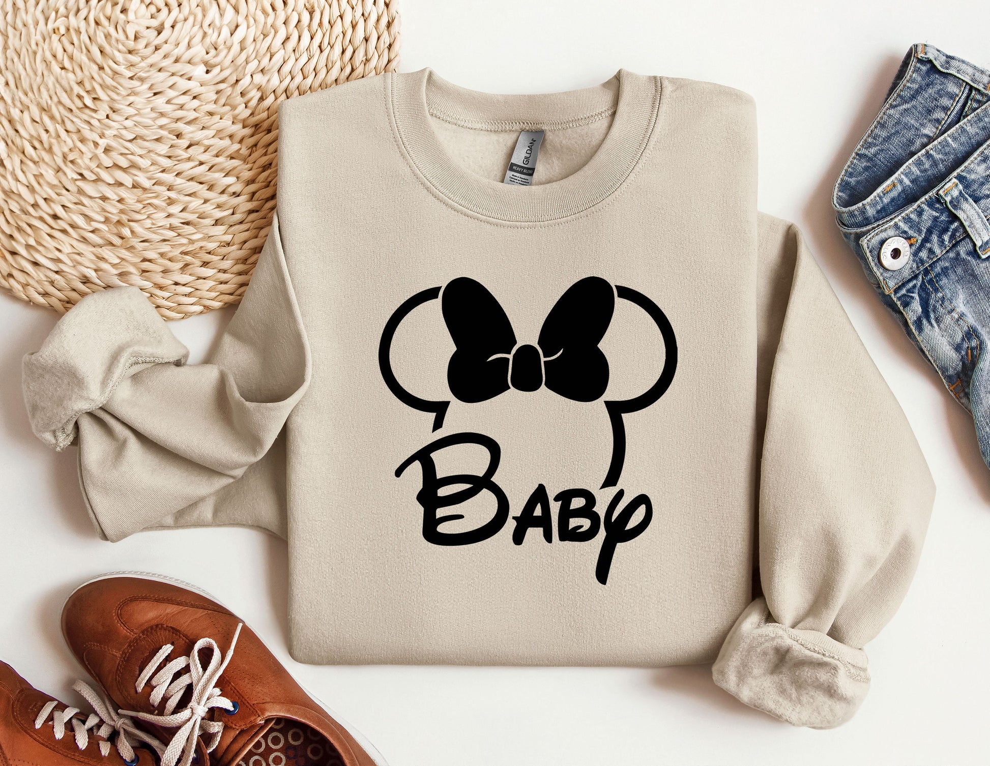 a sweater with a bow on it next to a pair of shoes