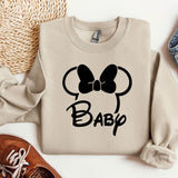 a sweater with a bow on it next to a pair of shoes