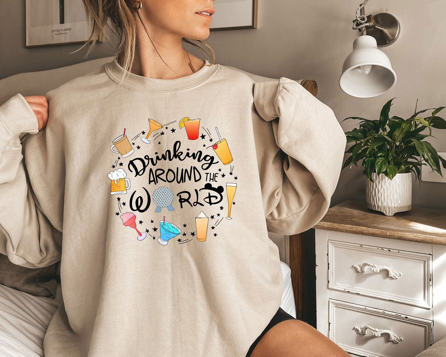 a woman wearing a sweatshirt that says drinking around the world