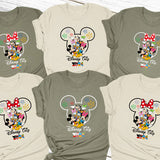 a group of mickey mouse shirts on a wooden surface
