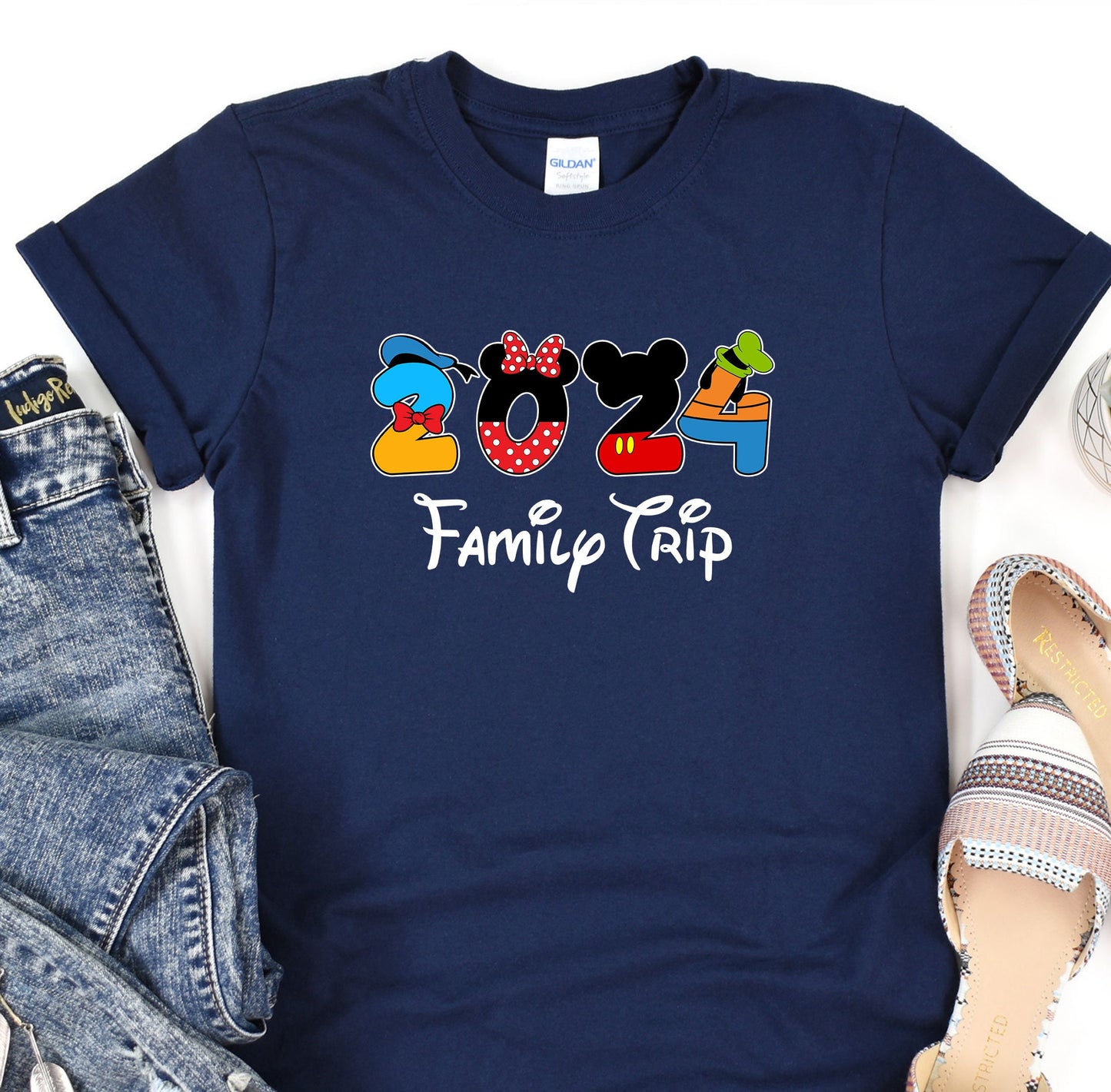 a mickey mouse family trip t - shirt next to a pair of jeans