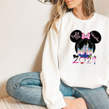a woman sitting on the floor wearing a mickey mouse shirt