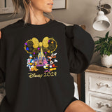 a woman holding onto a mickey mouse shirt