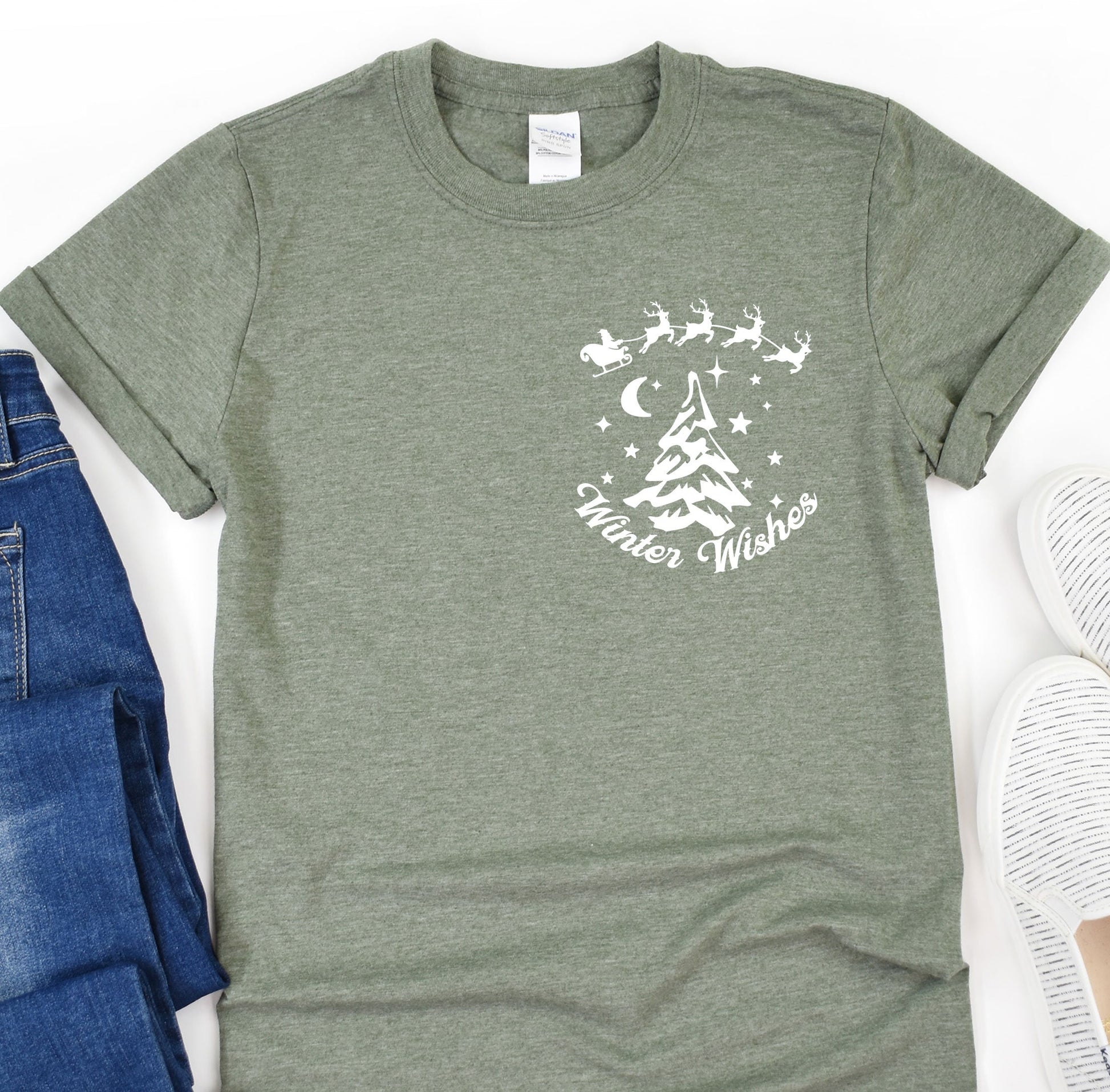 a t - shirt with a christmas tree on it next to a pair of jeans