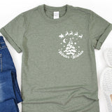 a t - shirt with a christmas tree on it next to a pair of jeans