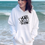 a woman standing on the beach wearing a white hoodie