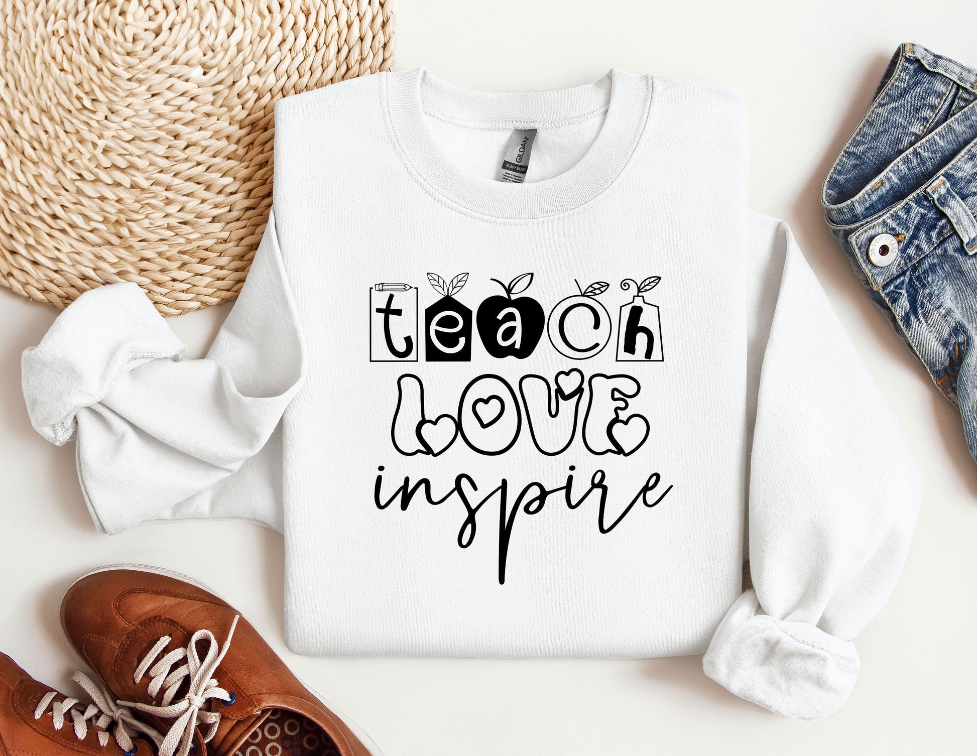 a white sweatshirt with the words teach love inspire on it