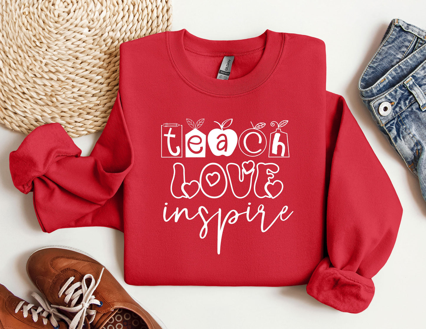 a red sweatshirt with the words teach love inspire on it