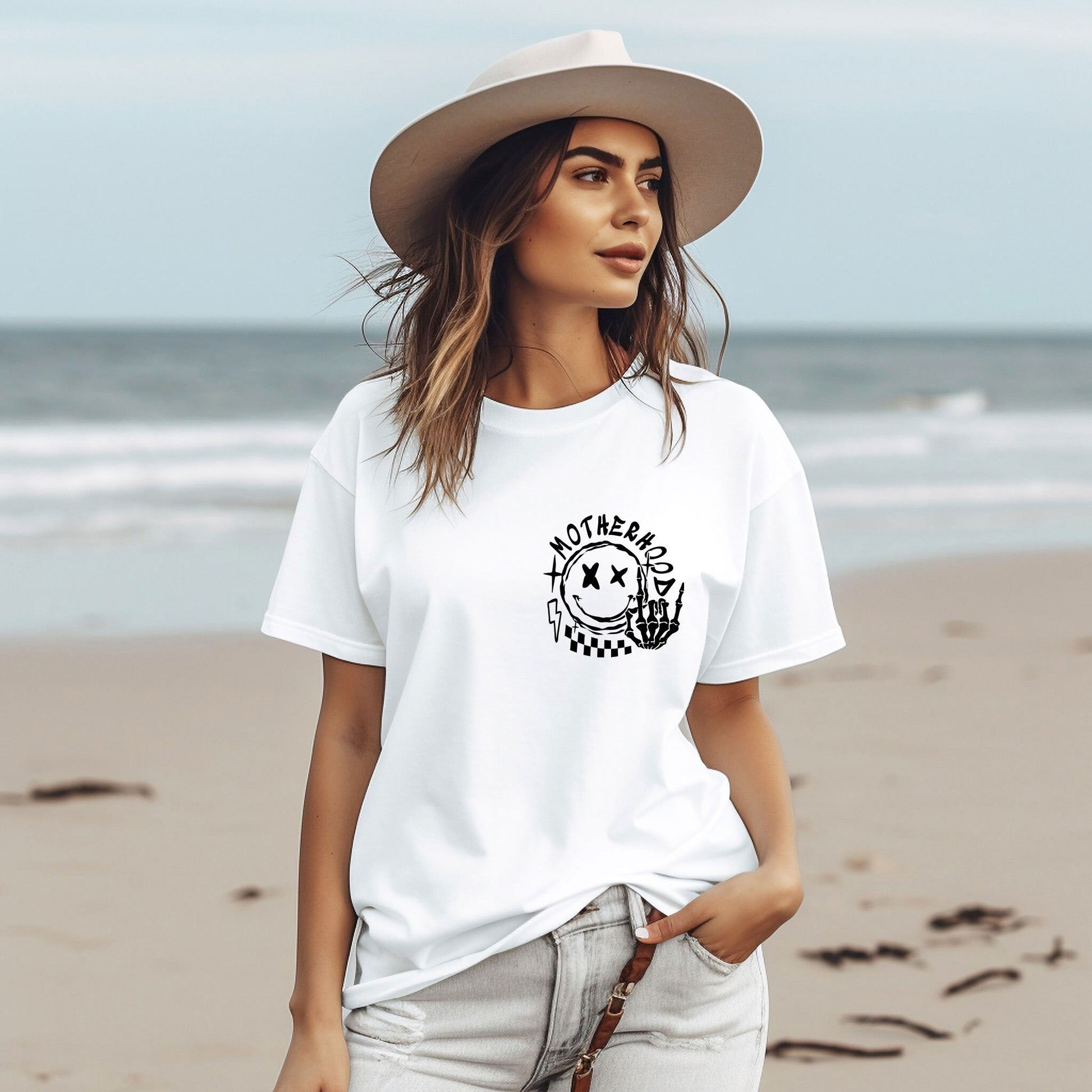 a woman standing on a beach wearing a hat