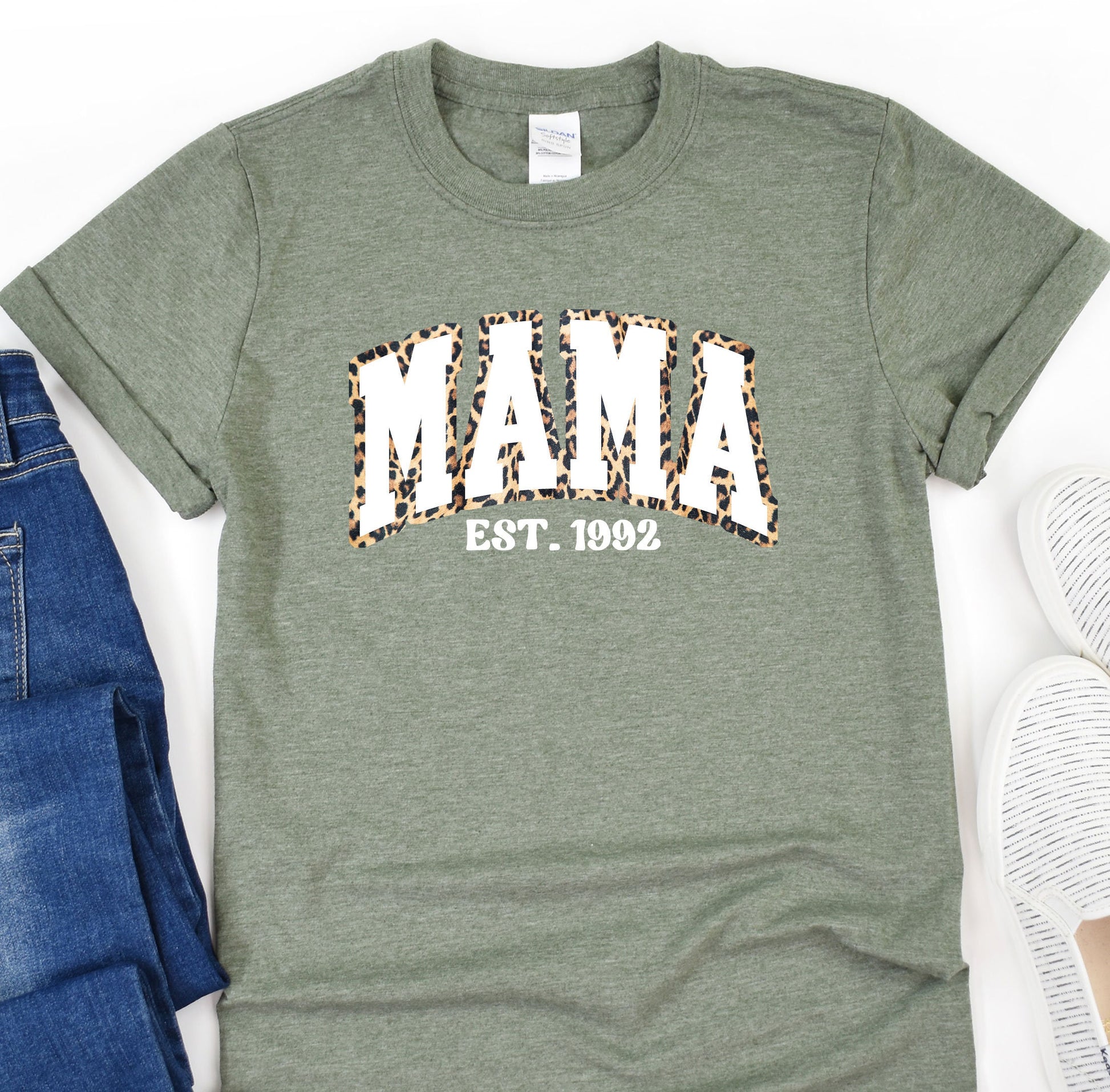 a t - shirt with the word mama on it next to a pair of jeans