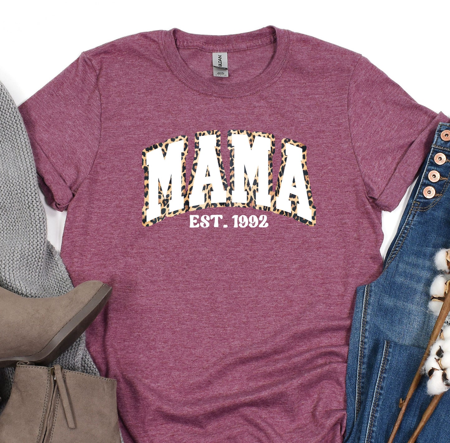 a t - shirt with the word mama on it next to a pair of jeans