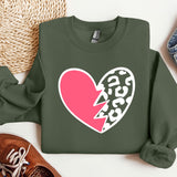 a green sweater with a pink heart and a broken heart