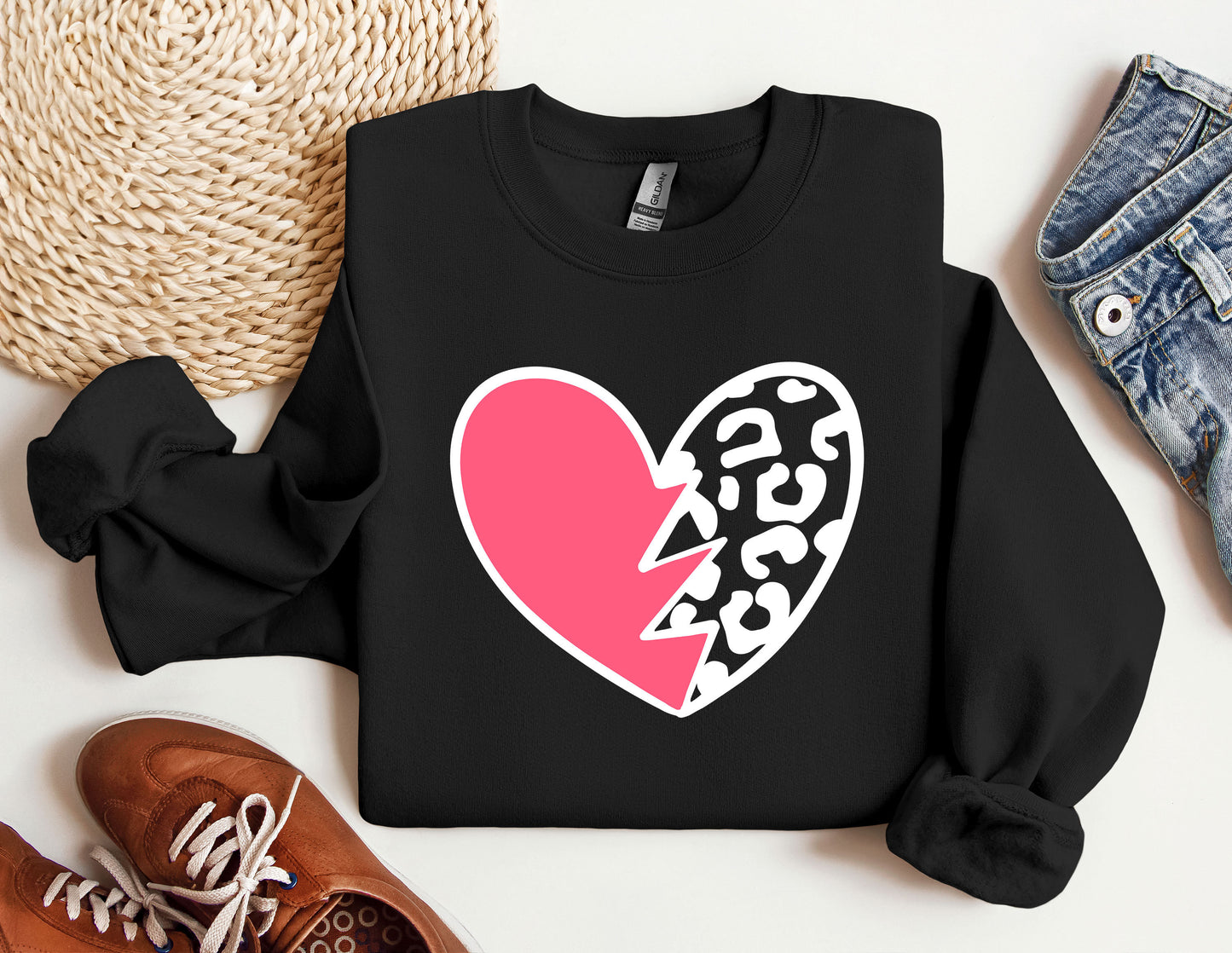 a black sweater with a pink heart and a broken heart