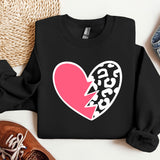 a black sweater with a pink heart and a broken heart