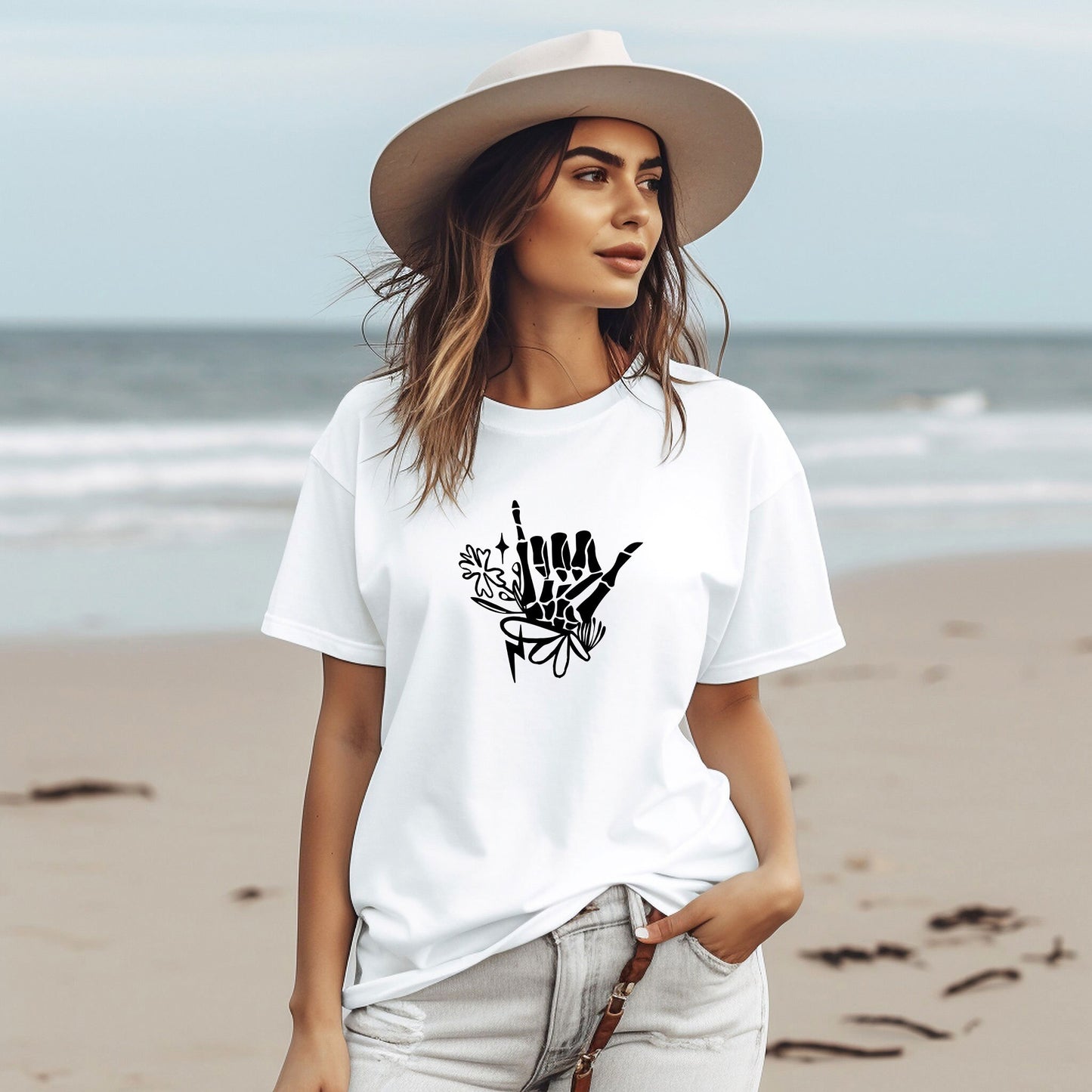 a woman wearing a white t - shirt and hat on the beach