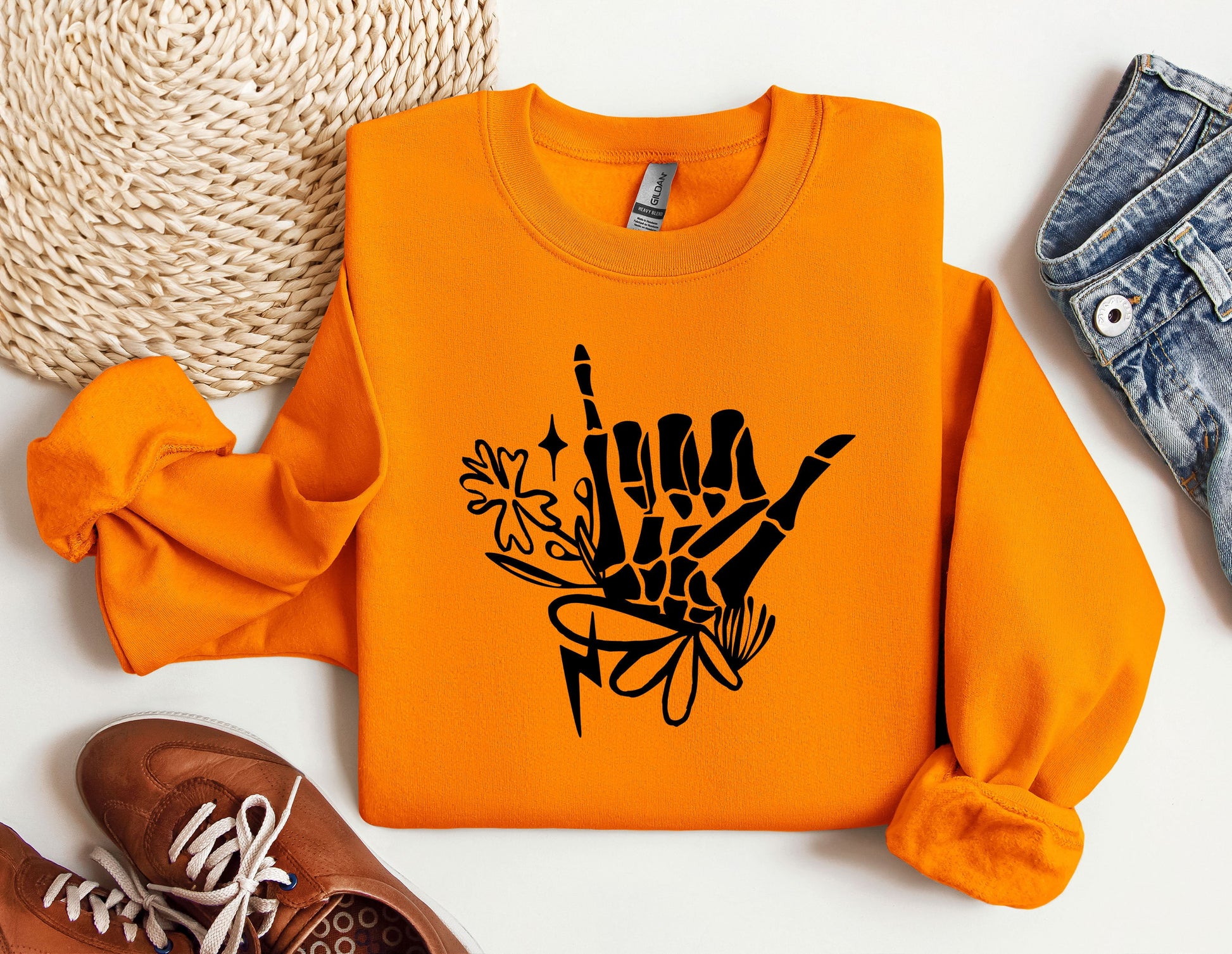 an orange sweatshirt with a black design on it