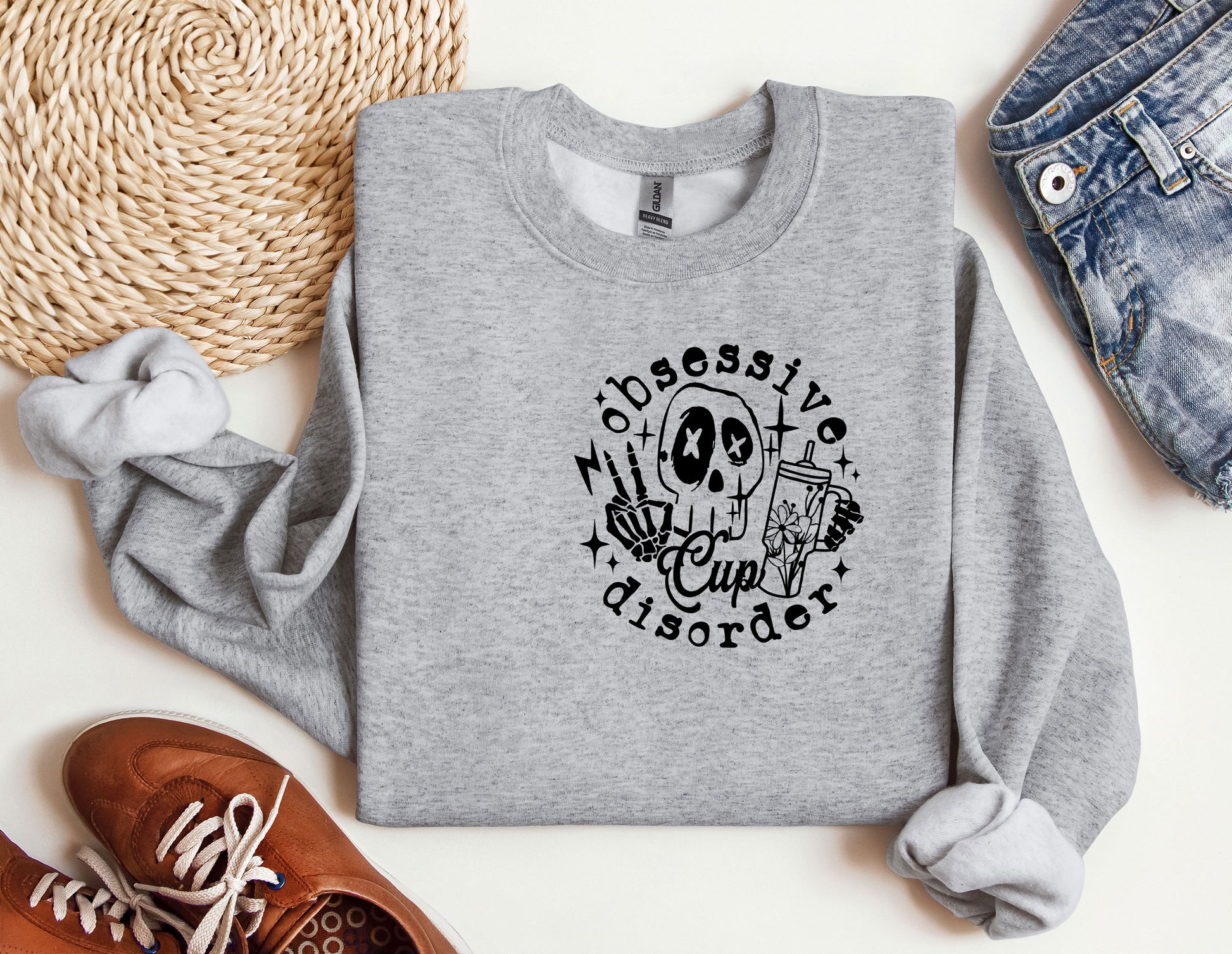 a grey sweatshirt with a skull and a cross on it