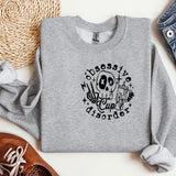 a grey sweatshirt with a skull and a cross on it