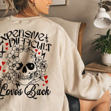 a woman sitting in a chair wearing a sweatshirt with a skull on it