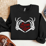 a black sweatshirt with the words love is back on it next to a pair of