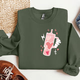 a green sweatshirt with a pink drink on it