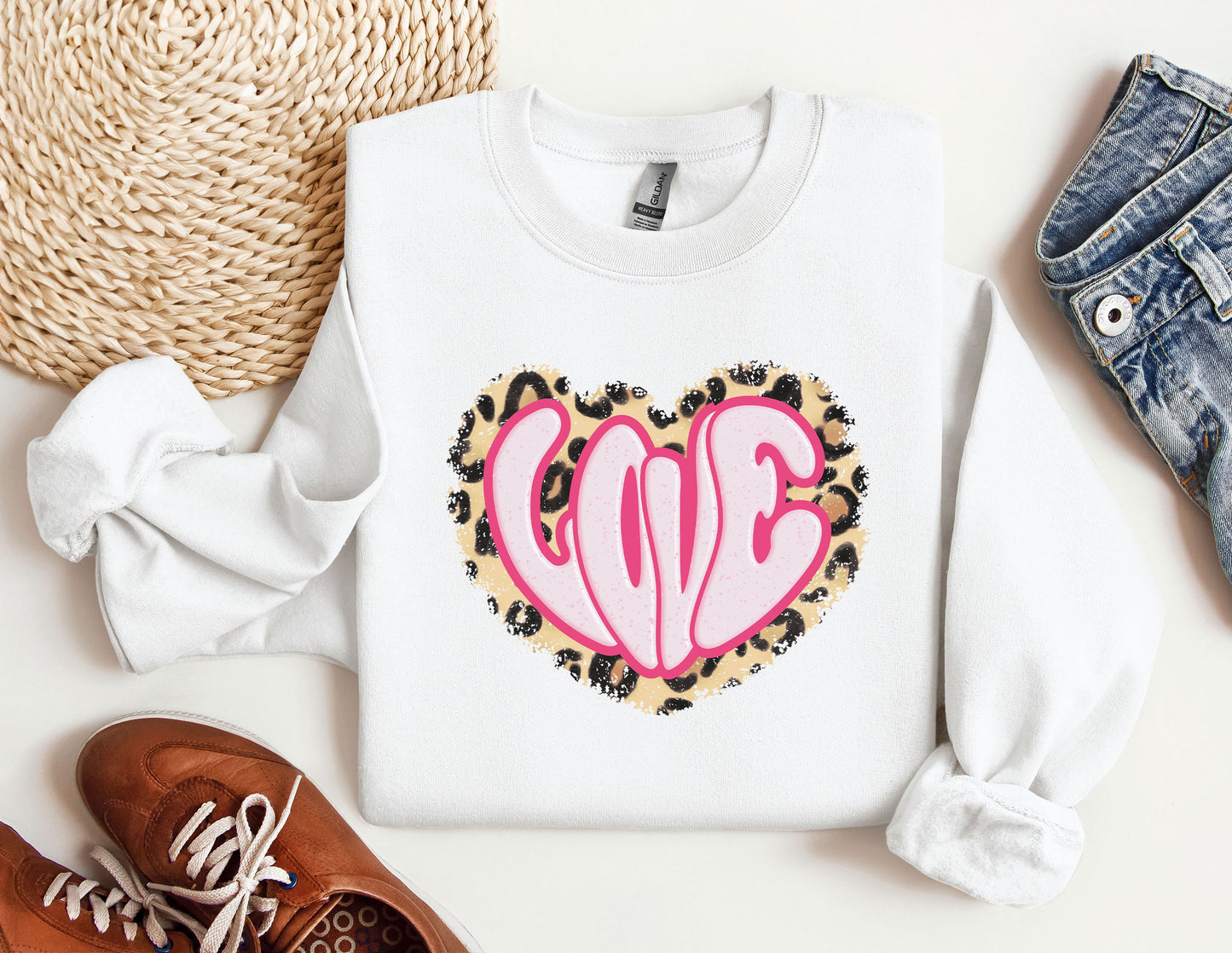 a white sweater with a pink heart on it