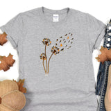 a t - shirt with a dandelion design on it