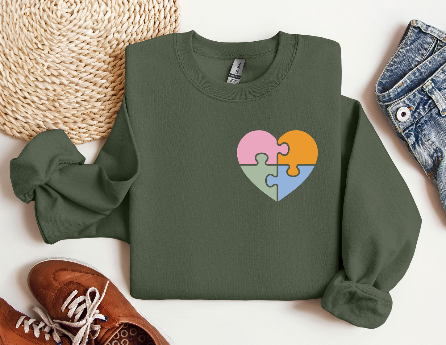 a green sweater with a puzzle heart on it